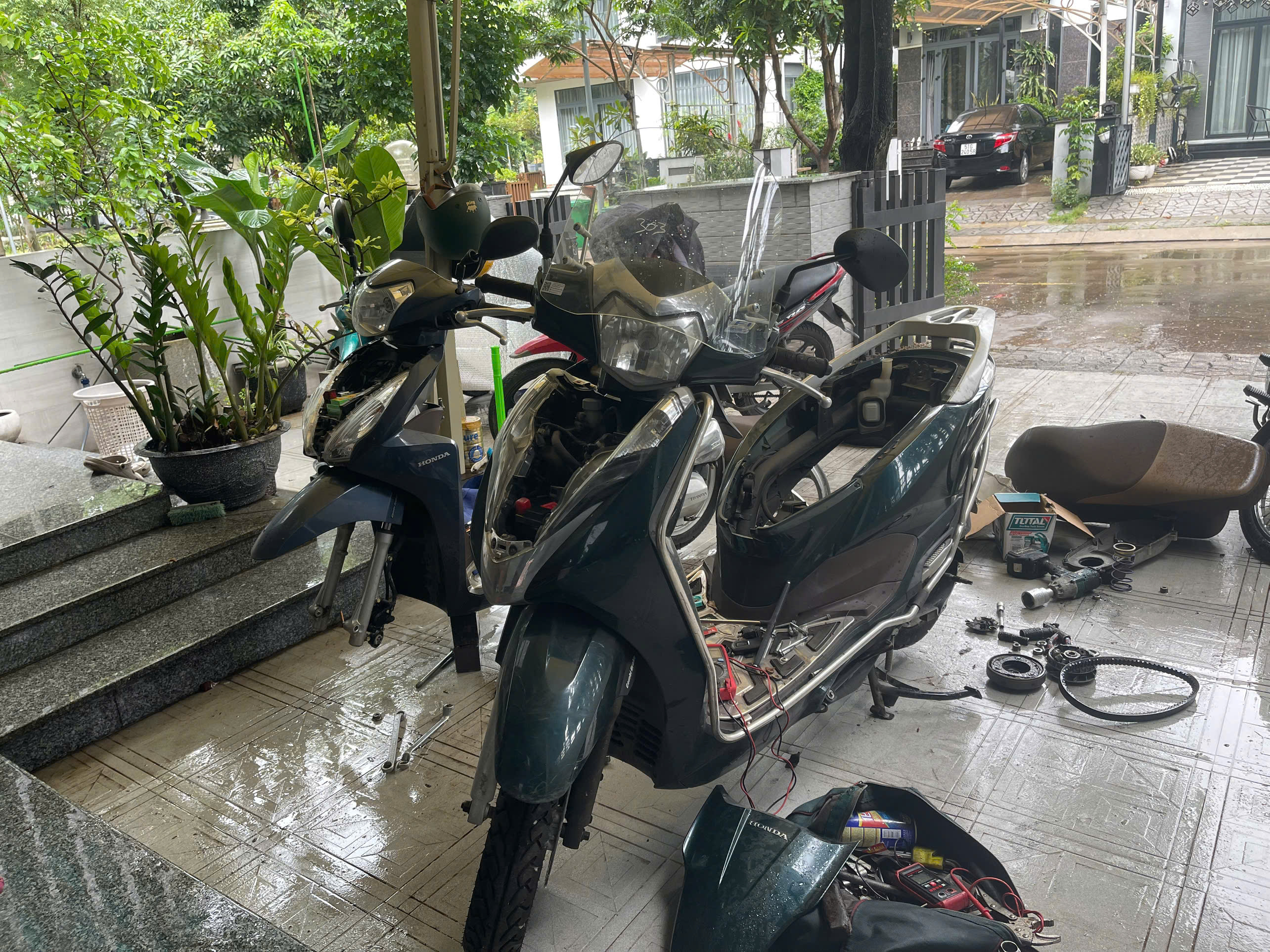 Kỹ thuật viên cứu hộ xe máy đang kiểm tra xe trên đường tại TP.HCM